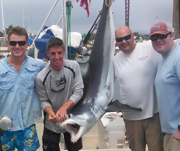 Captain Mike with His Fishermen and Their Shark